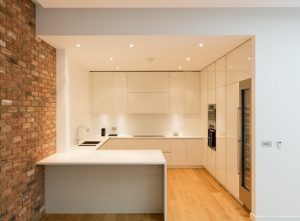 Cocina blanca sin tiradores abierta al salón