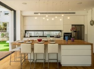 Cocina abierta al salón con gran isla central de roble