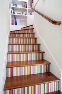 Escalera decorada con papel pintado multicolor en las tabicas de los escalones