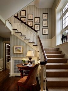 Escalera con papel pintado de rayas y friso de madera lacada