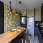 Cocina muebles negros y papel fondo mostaza