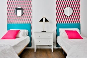 Dormitorio 2 camas con papel geométrico en cabeceros