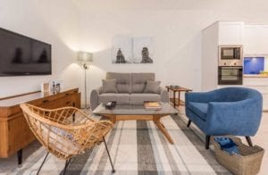 Jarapa a rayas en salón nórdico con sillón de terciopelo azul