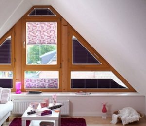 Combinación de cortinas plisadas en pared frontal de buhardilla